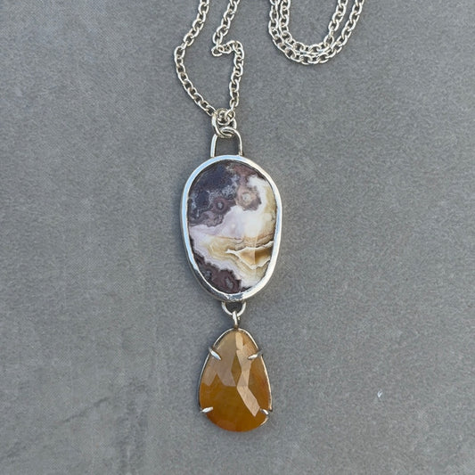 Purple, cream and ochre Crazy Lace Agate set in sterling silver, with a toffee coloured rose cut sapphire suspended below, set in silver prong setting. 